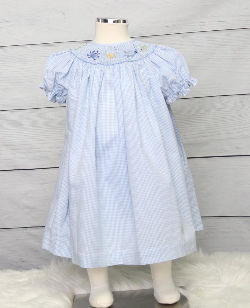 
Elevate your little one's wardrobe with this enchanting blue gingham smocked dress. Expertly crafted with handmade smocking, this charming bishop dress features intricate geometric patterns and delicate tiny sea creatures, adding a whimsical touch to its classic design. The combination of timeless blue gingham and the playful, hand-embroidered details makes this dress perfect for any special occasion. Ideal for capturing attention and creating memorable moments, this dress blends elegance and fun in a way 